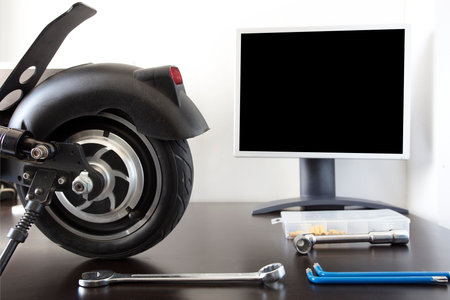 Electric scooter on a bench in a specialized workshop near the monitor. Maintenance service concept. Repair service. Technological conceptの写真素材
