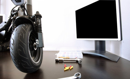 Electric scooter on a bench in a specialized workshop near the monitor. Maintenance service concept. Repair service. Technological conceptの写真素材