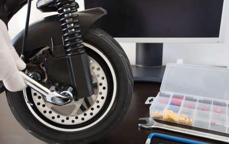 Electric scooter on a bench in a specialized workshop near the monitor. Maintenance service concept. Repair service. Technological conceptの写真素材