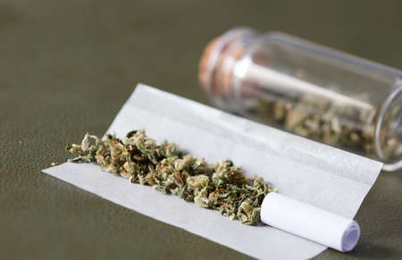 Marijuana buds with marijuana joints, with cardboard filter, cigarette paper, and storage canisterの写真素材