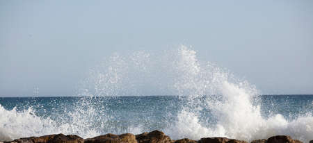 Waves splashed over rocks on a very windy dayの写真素材