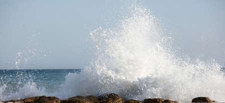 Waves splashed over rocks on a very windy dayの写真素材