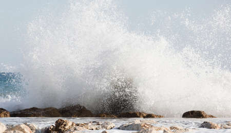 Big waves crash onto the shore with marine foamの写真素材