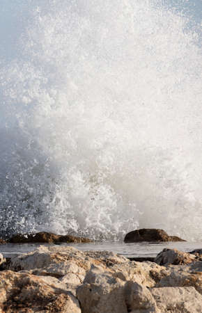 Big waves crash onto the shore with marine foamの写真素材