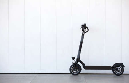 Personal mobility vehicle, electric scooter (e-scooter), parked in the city with white wall backgroundの写真素材