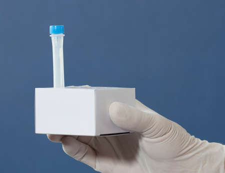 nurse's hands with surgical gloves, medium transport tubes for pcr analysis, in cardboard holder, blue backgroundの写真素材
