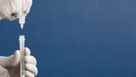 nurse or doctor performs antigen test, with blue background.の写真素材