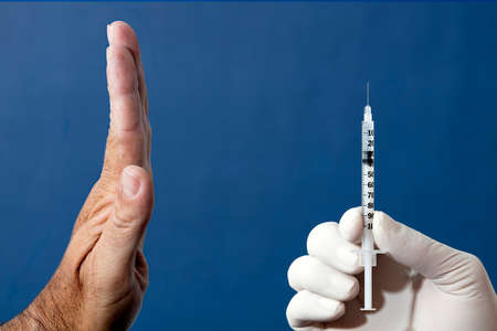 Denial of medical vaccination concept. Stop the medical injection. Refuse the vaccine medication. Protest against vaccination, man's hand rejecting preventive medicine. Trypanophobia.の写真素材