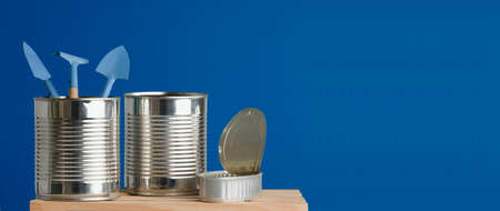 three recycled cans on wooden table blue backgroundの写真素材