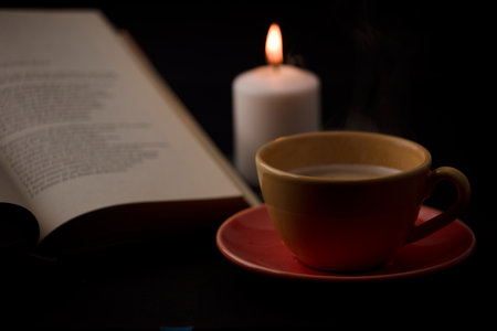 cup of tea with hot smoke and lit candle. on the desk at home, power outage (focus on cup).の写真素材