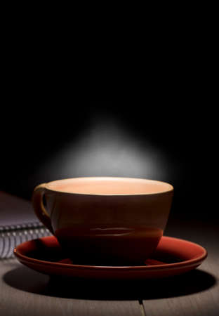 hot yellow mug with steam on desk table space for textの写真素材