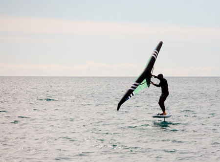 sportsman with wingfoil sailing, in the seaの写真素材