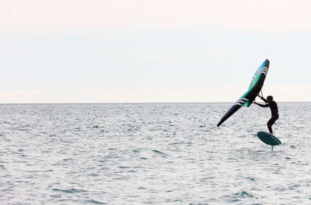sportsman with wingfoil sailing, in the seaの写真素材