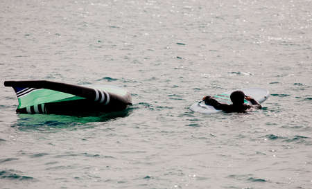 man in the water with neoprene wing foil helmet and hydrofoil equipment.の写真素材