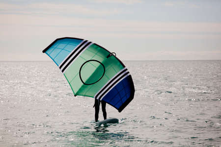 sportsman with wingfoil sailing, in the seaの写真素材