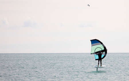 sportsman with wingfoil sailing, in the seaの写真素材