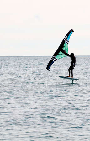 sportsman with wingfoil sailing, in the seaの写真素材