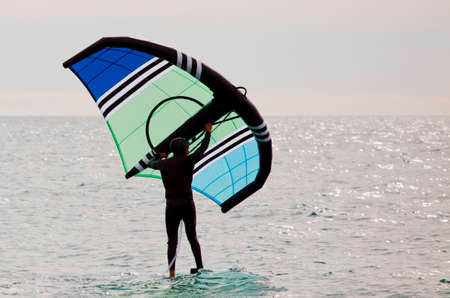 sportsman with wingfoil sailing, in the seaの写真素材
