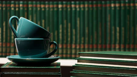 two green cups of hot coffee, with books.の写真素材