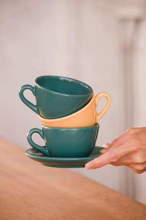 stack of coffee cups in woman hands. Focus on the cup.の写真素材