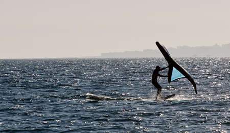 young man with wingfoil on the beachの写真素材