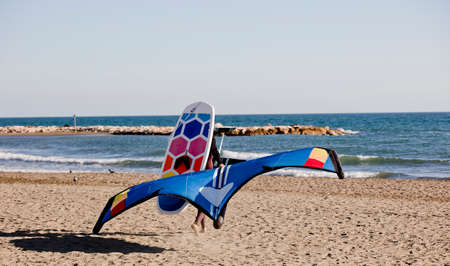 man with wing foil board and sports equipment on the beachの写真素材