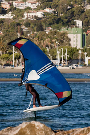 young man with wingfoil on the beachの写真素材