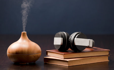 Relaxation at home with aromatherapy oil diffuser and headphones with book. Aroma essence of health, wellness aromatherapy home aromatic tranquil therapy.の写真素材
