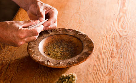 man hands prepare marijuana cigar at homeの写真素材