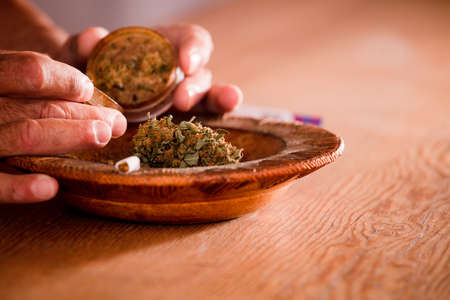 man hands with marijuana grinder at homeの写真素材