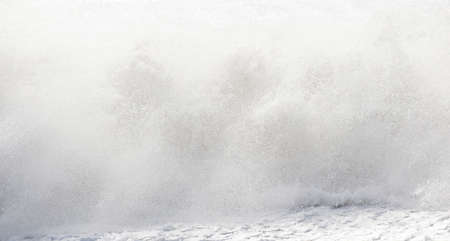 big waves breaking on the shore, with white foamの写真素材