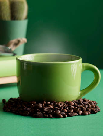 cup of hot green coffee with steam, coffee beans, cactus, space for text, green background.の写真素材