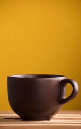 brown cup with coffee or chocolate, with yellow backgroundの写真素材