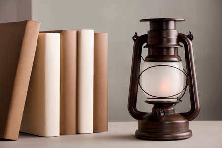 brown solar lamp on table with books different shades of brown, gray backgroundの写真素材