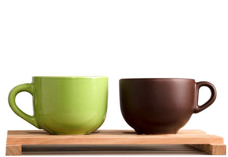 two brown and green cups of coffee or tea on wood with white backgroundの写真素材