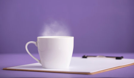 cup of hot tea or cade with purple background, on workbookの写真素材