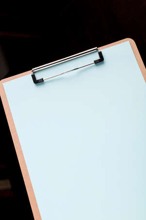 notepad with blue sheet and black backgroundの写真素材