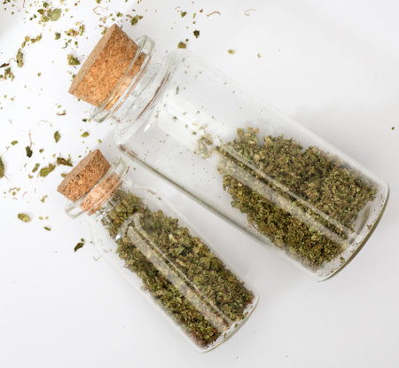 ground marijuana inside glass bottles with corks, white backgroundの写真素材
