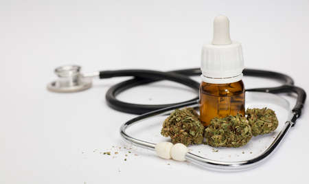 set of marijuana buds, with dosing bottle, stethoscope, white background.の写真素材