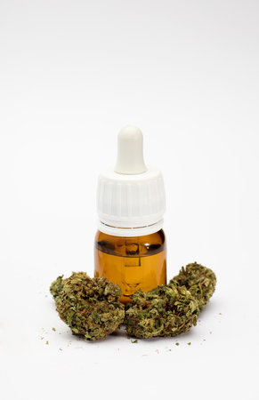 set of marijuana buds, with dispenser bottle, white background.の写真素材