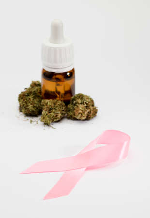 pink ribbon, set of marijuana buds, with dispenser bottle, white background.の写真素材