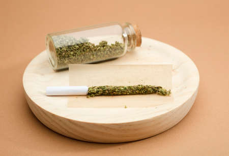 CBD (Cannabidiol) oil with bottle and dropper with buds. brown background. CBD isolated hemp oil. THC freeの写真素材
