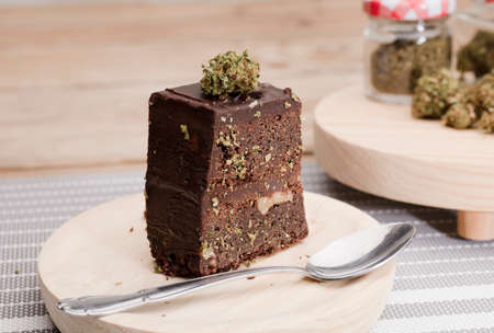 Chocolate cupcake muffins with cannabis buds. Marijuana hemp medical drugs in food dessert. Chocolate herb muffins cooking. Marijuana cake on a brown wooden table.の写真素材