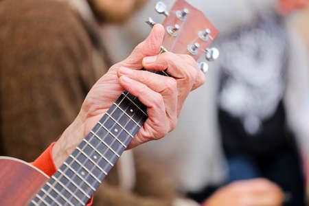 Guitar Player Hand or Musician's Hand in F Major Chord on Acoustic Guitar String in Soft Natural Light in Side Viewの写真素材