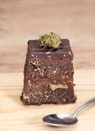 marijuana brownie on wooden spoon on kitchen tableの写真素材