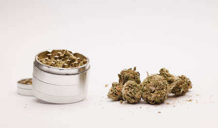 Marijuana format buds with aluminum grinder, white background.の写真素材