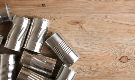 recycled cans, reused on a table with a wood brown background