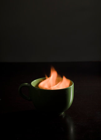 cup of coffee with fire inside, black backgroundの写真素材