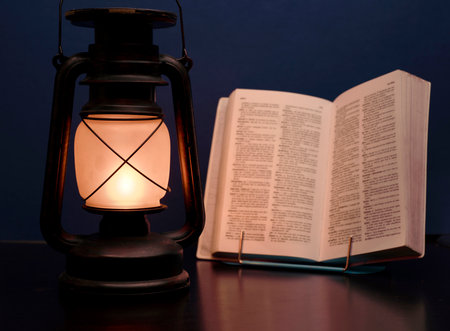 old lamp illuminates book, concept power outagesの写真素材