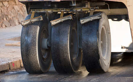 Road construction equipment coating asphalt black top lane